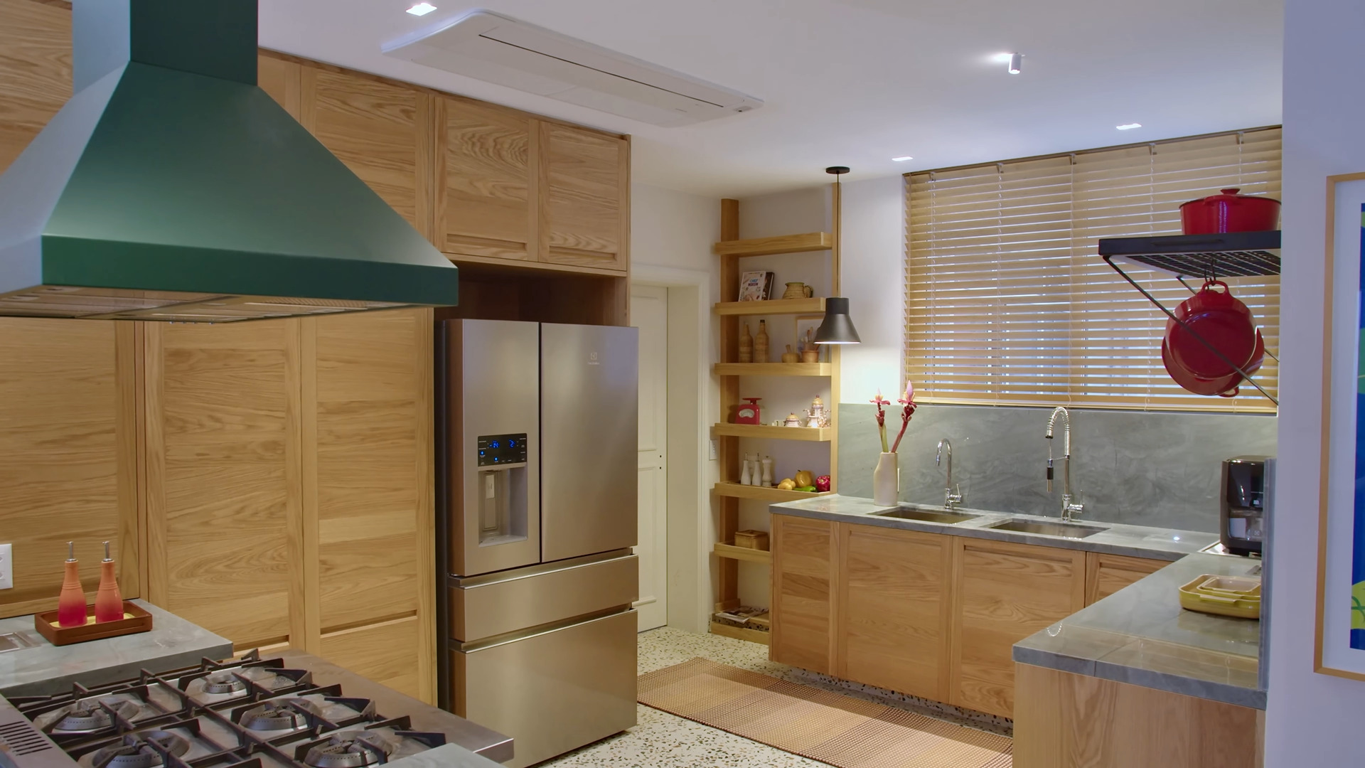 Entre as mudanças estruturais está a integração da cozinha ao living, o que permite que Lázaro cozinhe enquanto conversa com os amigos.