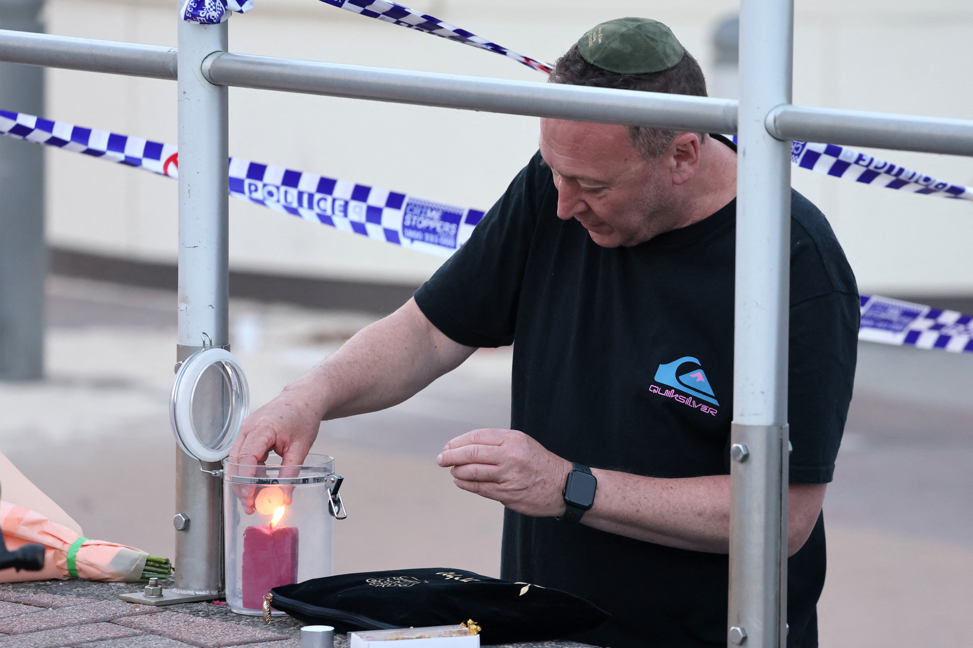 MEMBRO da comunidade judaica acende vela no local do tiroteio (Foto: DAVID GRAY)