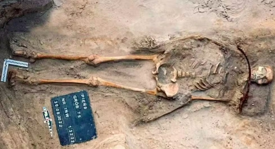 A jovem de 18 anos estava sepultada com uma foice sobre o pescoço e um cadeado no dedo do pé, medidas usadas para impedir que ela “retornasse dos mortos” – uma prática de proteção contra supostos “vampiros”.  O corpo da jovem tinha deformidade física e a comunidade pode ter considerado anormal.