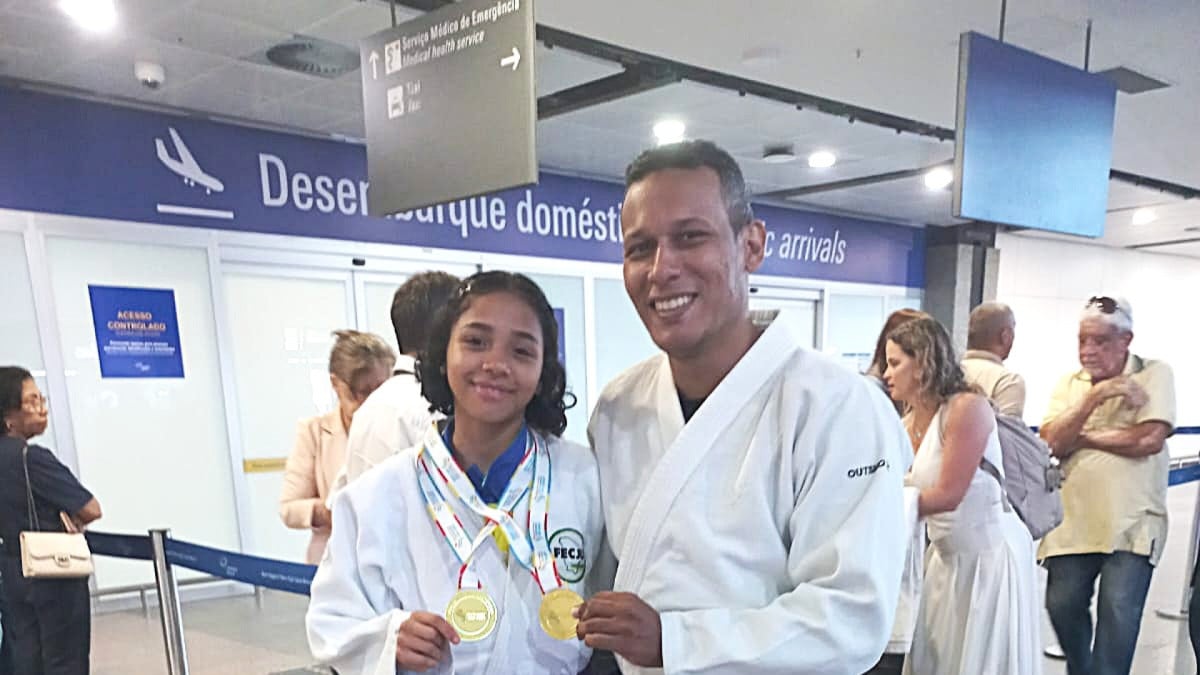 Ana Mikaele posa com a medalha de ouro ao lado do treinador Sensei Francisco Choles