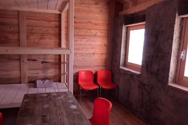 O interior é simples e apertado, com uma beliche, duas portas e pequenas janelas, além de uma mesa e algumas cadeiras.