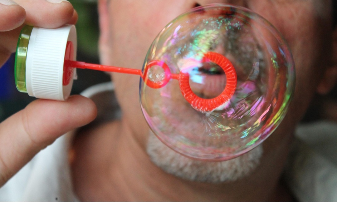 As bolhas de sabão são fenômenos físicos formados pela tensão superficial da água, modificada pela ação do detergente, que cria uma película elástica com camadas de moléculas de água e sabão. 