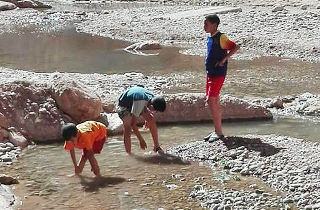 O rio Todra forma pequenas poças e córregos que refletem as paredes rochosas, criando espelhos naturais. Em dias calmos, a água parece parada no tempo. Crianças locais brincam nas margens, dando vida ao cenário.