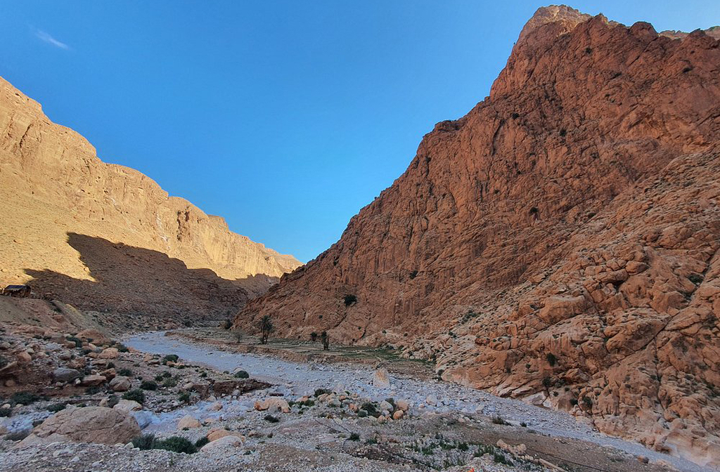 O desfiladeiro foi moldado ao longo de milênios pela força do rio Todra, que ainda serpenteia entre as rochas. A erosão contínua esculpiu formas únicas e cavernas ocultas nas encostas. A paisagem é viva, em constante transformação, mesmo que imperceptível aos olhos.