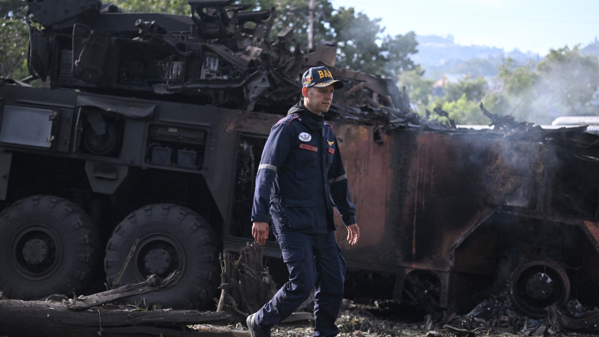 Um bombeiro passa por um veículo militar incendiado na base aérea de La Carlota, em Caracas, em 3 de janeiro de 2026, após as forças americanas capturarem o líder venezuelano Nicolás Maduro depois de lançarem um 