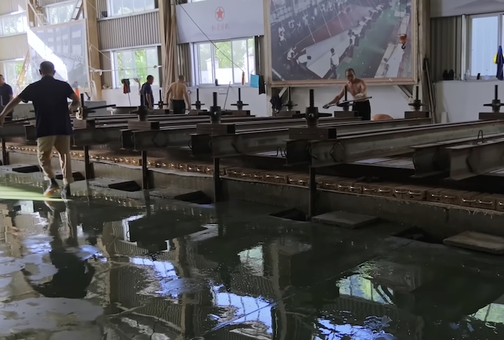 Em seguida, a folha passa por prensagem com vigas de aço pesadas para retirar água e estabilizar sua estrutura.