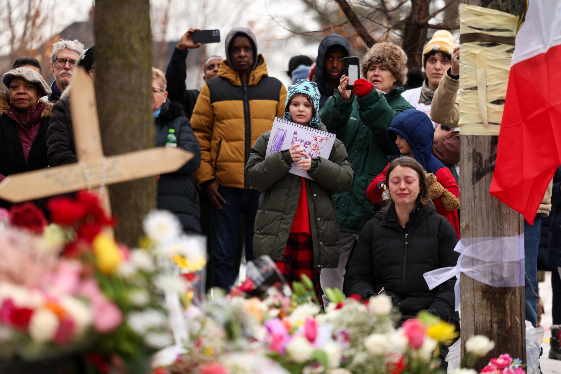 Pessoas se reúnem na rua onde Renee Nicole Good, de 37 anos, foi baleada e morta à queima-roupa em 7 de janeiro por um agente do Serviço de Imigração e Alfândega dos EUA (ICE), enquanto aparentemente tentava fugir de agentes que cercavam seu carro, em Minneapolis, Minnesota, em 8 de janeiro de 2026.
Um agente do Serviço de Imigração e Alfândega dos EUA (ICE) atirou e matou uma mulher americana nas ruas de Minneapolis em 7 de janeiro, o que levou a enormes protestos e indignação de líderes locais que rejeitaram as alegações da Casa Branca de que ela era uma terrorista doméstica. A mulher, identificada pela mídia local como Renee Nicole Good, de 37 anos, foi atingida à queima-roupa enquanto aparentemente tentava fugir de agentes que cercavam seu carro, que, segundo eles, estava bloqueando o caminho. (Foto: CHARLY TRIBALLEAU / AFP)