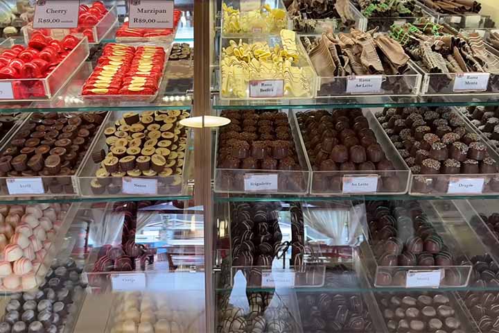 Restaurantes especializados em fondues, chocolates artesanais, cafés e vinhos tornaram-se parte do cotidiano da vila, criando uma atmosfera acolhedora que convida a caminhar sem pressa pelas ruas, muitas vezes envoltas por névoa.
