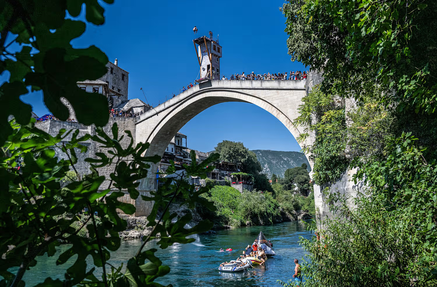 Saltadores locais realizam mergulhos de 24 metros da ponte para o Neretva, tradição que remonta ao período otomano. O salto exige coragem e técnica, e muitos treinam desde jovens para participar. Turistas podem assistir ou até pagar para saltar com supervisão especializada.