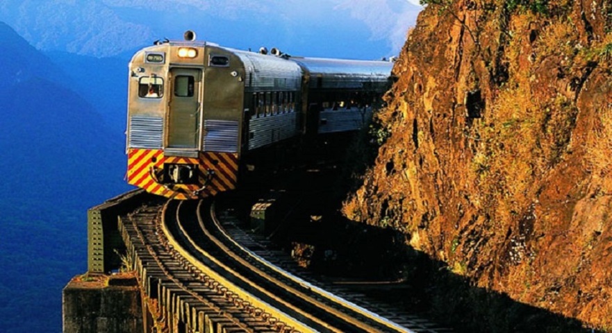 Trem de Curitiba a Morretes (PR) - Um dos passeios de trem mais famosos do Brasil, o trajeto atravessa a Serra do Mar por trilhos históricos construídos em 1885 para exportação de erva-mate e madeira. A locomotiva serpenteia pela Mata Atlântica preservada, entre montanhas, pontes estreitas e paredões de pedra. A vista impressiona e a viagem é uma verdadeira imersão na natureza e na história.