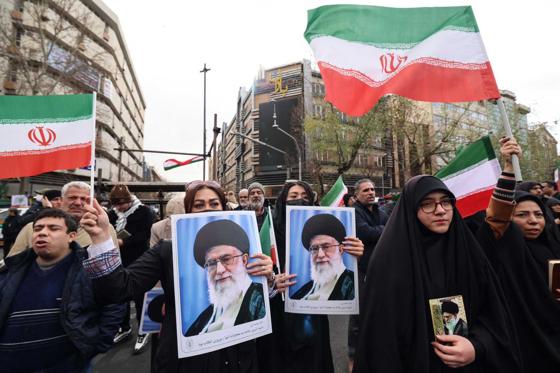 MULHERES iranianas seguram retratos do aiatolá Ali Khamenei, durante os funerais de membros das forças de segurança mortos em protestos recentes 
em Teerã (Foto: ATTA KENARE / AFP)