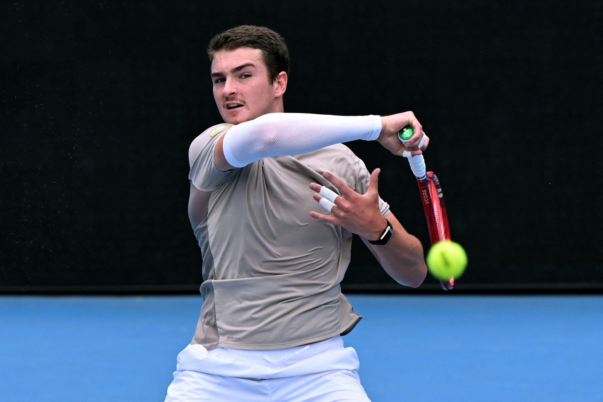 João Fonseca, do Brasil, rebate uma bola durante um treino em Melbourne, em 15 de janeiro de 2026, antes do início do torneio de tênis Australian Open, em 18 de janeiro. (Foto: WILLIAM WEST / AFP)