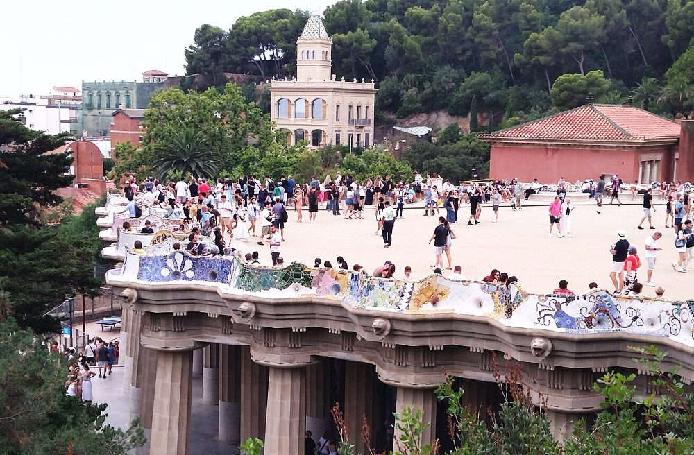 No coração do parque está a grande praça, conhecida como Praça da Natureza ou Sala Hipóstila. Cercada por bancos ondulados cobertos de mosaicos, é um espaço de convivência e contemplação. As colunas abaixo sustentam a praça e lembram uma floresta petrificada. Ali, Gaudí uniu funcionalidade e estética em perfeita harmonia. É um dos pontos mais emblemáticos do parque.