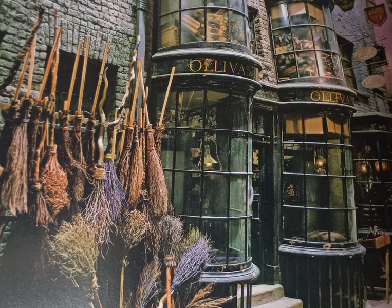 <p>Olivaras – É a tradicional loja de varinhas localizada no Beco Diagonal, fundada em 382 a.C. É lá que Harry Potter compra sua primeira varinha, e o próprio Sr. Olivaras ajuda os bruxos a encontrar a varinha ideal. Craig criou uma loja rica em detalhes, com clima escuro, de sombras.</p>
