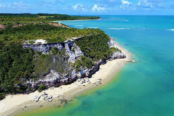 <p>No Brasil, a Praia do Espelho, na Bahia, combina falésias, coqueiros e areia branca. A maré baixa forma piscinas naturais, ideais para banho e contemplação.</p>
