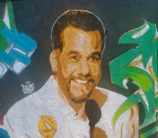 <p>A obra é assinada pelo artista Filipe Harp, o mesmo que criou um mural em celebração à vitória de Fernanda Torres na premiação. A conquista de Moura marcou um feito inédito, já que ele se tornou o primeiro brasileiro a vencer na categoria.</p></div>

<!-- INTERBANNER 5 [RETANGULO(BR)] - DESKTOP - [INTERNAS] -->
<div class=