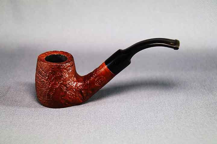 <p>O cachimbo é composto por um fornilho, onde se coloca o fumo, e um tubo ou haste, que direciona a fumaça ao fumante. Ele é valorizado por sua construção artesanal, feita de materiais como madeira, cerâmica ou argila, e pela experiência mais lenta e reflexiva que proporciona.</p></div>

<!-- INTERBANNER 5 [RETANGULO(BR)] - DESKTOP - [INTERNAS] -->
<div class=