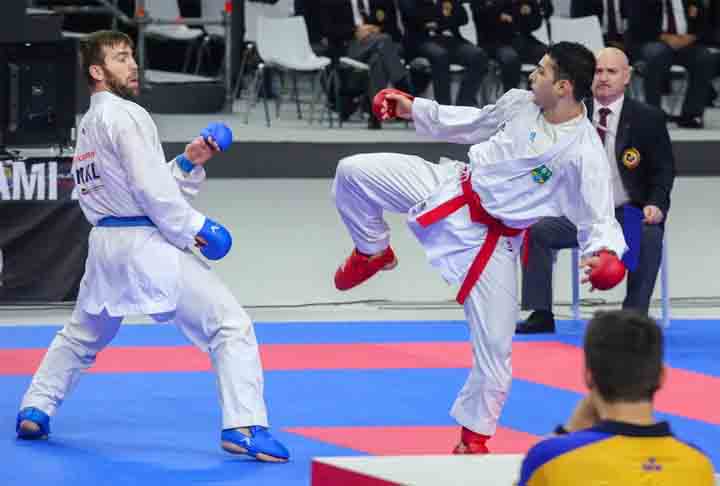 <p>Karatê- Originário de Okinawa, no Japão, o caratê (já aportuguesado) foi influenciado por artes marciais chinesas com golpes de mãos, chutes, joelhadas e cotoveladas, além de posições de defesa e ataque. Foca o desenvolvimento do caráter dos praticantes, além da aptidão física.</p>
