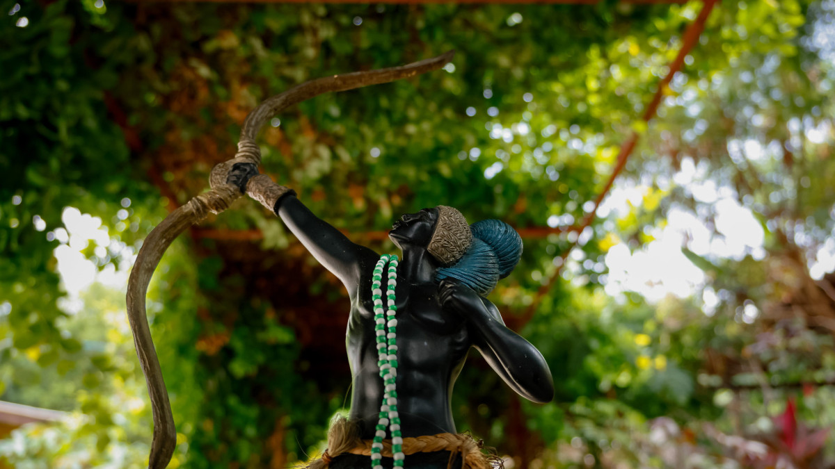 No Brasil, o dia de 20 de janeiro marca o encontro entre o padroeiro do Rio de Janeiro e o Rei das Matas. Na foto, representa&ccedil;&atilde;o do orix&aacute; Ox&oacute;ssi nas matas, segurando seu arco e flecha (of&aacute;) e vestindo paramentos nas cores verde e azul