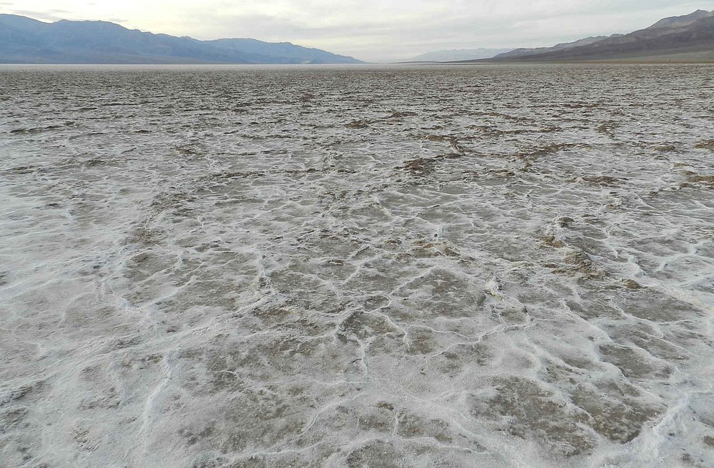A água é essencial para que as pedras se movam. Após chuvas raras, a planície se transforma em um lago raso que congela durante noites frias. O gelo fino prende parcialmente as pedras, mas ao derreter, cria placas que deslizam suavemente. Esse processo reduz o atrito e permite que ventos leves empurrem as rochas. Sem água, o solo seco é duro demais para permitir qualquer movimento.
