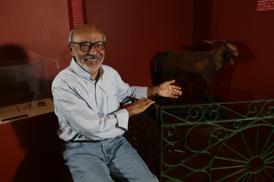 Gilmar de Carvalho, professor de cultura popular, pesquisador e escritor, posa ao lado da r&eacute;plica do Bode I&ocirc;i&ocirc;, no Museu do Cear&aacute;.