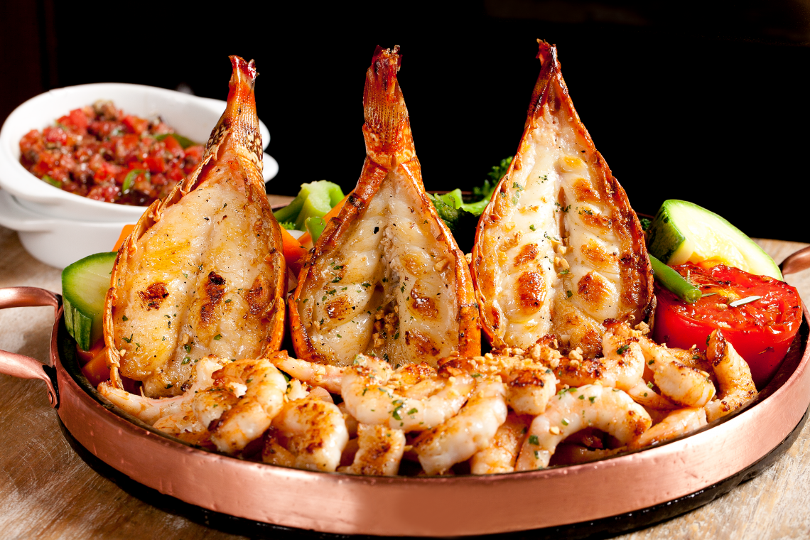 O prato: Tr&ecirc;s caudas de lagosta e camar&otilde;es grelhados com azeite e alho. Acompanham legumes salteados, arroz com br&oacute;colis e azeite aromatizado.    