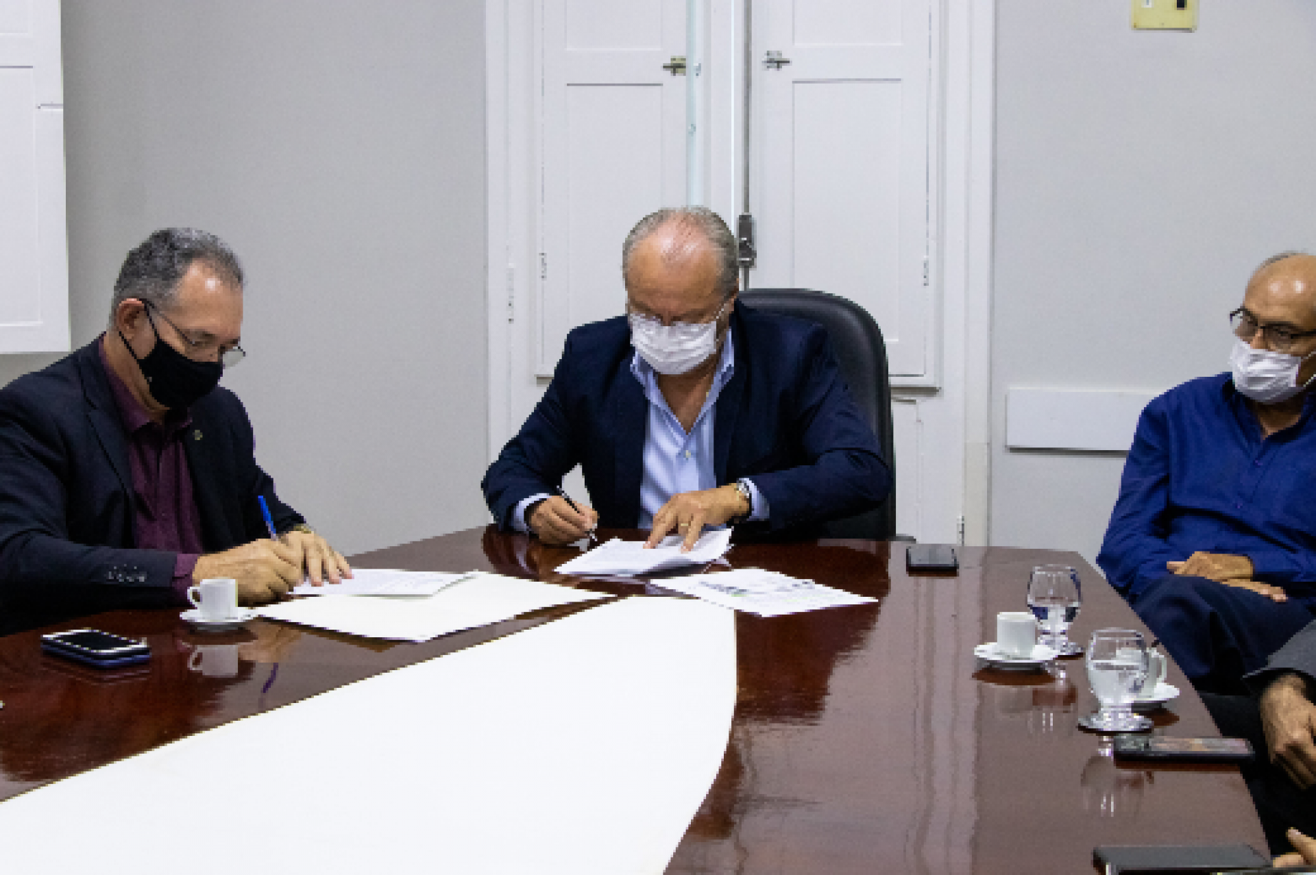 O superintendente da SPU, coronel Vandesvaldo Carvalho, e o reitor da UFC, Prof. Cândido Albuquerque, assinam o termo de cessão de uso do edifício.