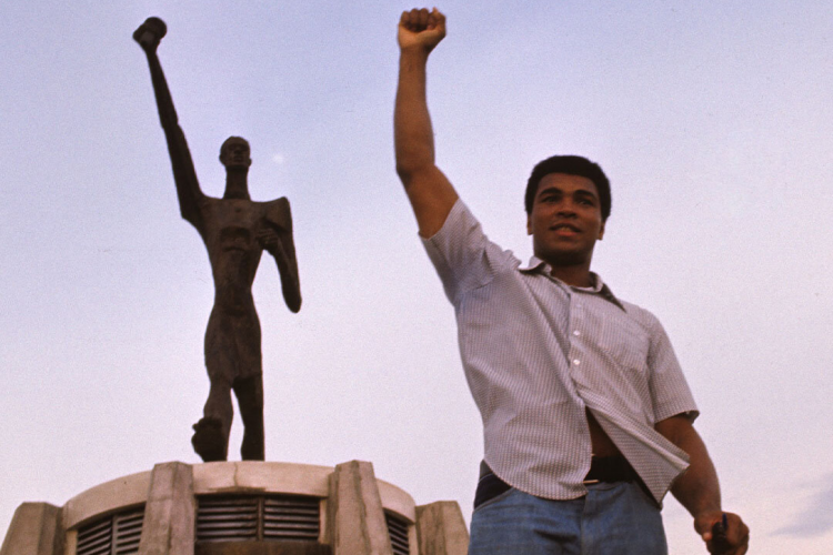 Muhammad Ali posando na frente da estátua Le Militant, N’Sele, Zaire.