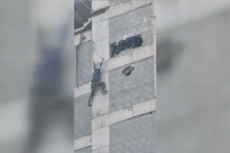 Homem pendurado teve apoio de três colegas ao ser resgatado