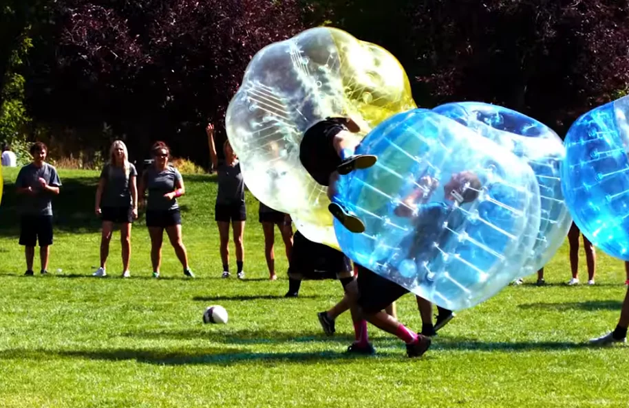 Os jogadores ficam apenas com as pernas de fora, para chutar a bola.  E a bolha permite que façam manobras engraçadas, se chocando uns com os outros sem risco de acidente. 