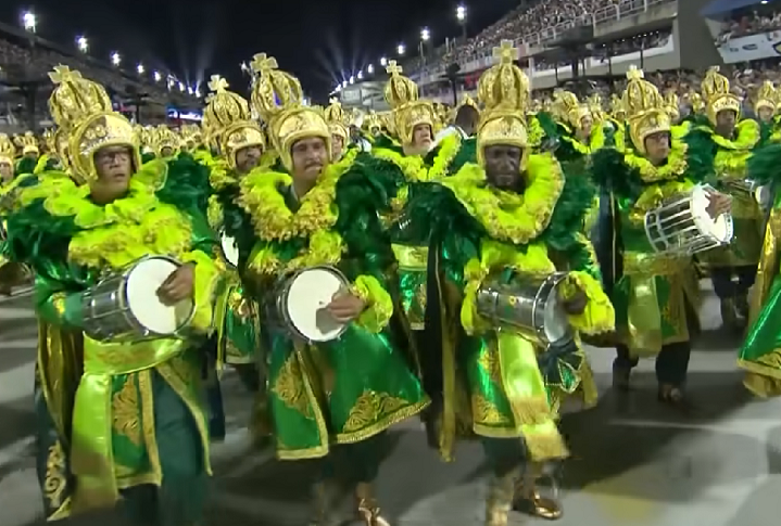 Império Serrano - Mais uma escola prejudicada pelo incêndio na fábrica de fantasias, a tradicional Império Serrano, de Madureira, fecha os desfiles da Série Ouro 2025 com o enredo O Que Espanta Miséria é Festa, em homenagem ao compositor e baluarte da escola Beto sem Braço, morto em 1993.