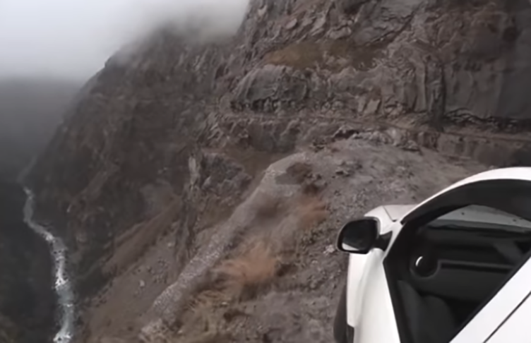 A estrada não é asfaltada, não possui qualquer mureta de proteção e, ainda por cima, uma cachoeira cai diretamente na estrada, provocando correnteza.