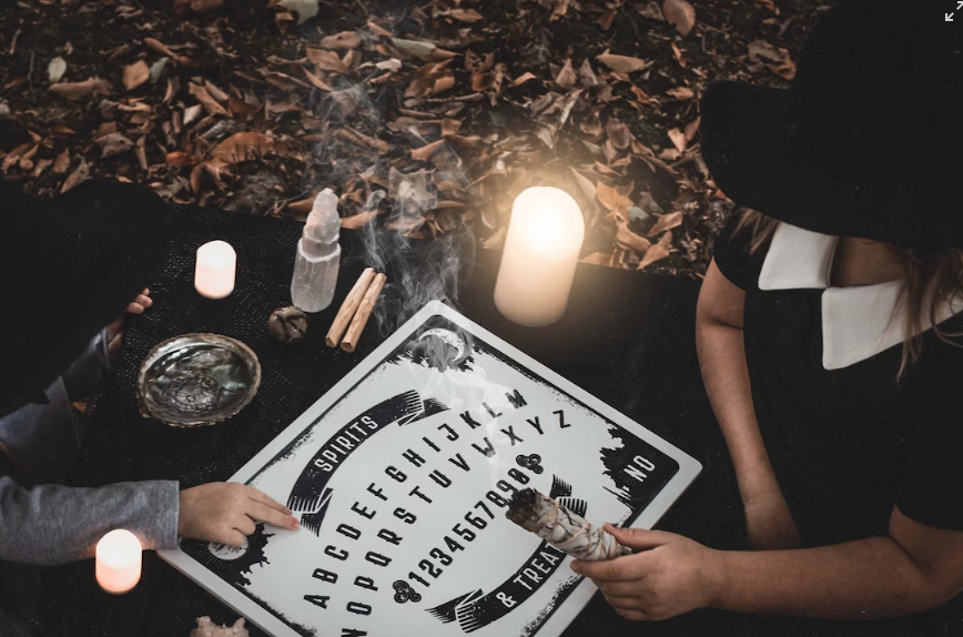 O Ouija é manipulado da seguinte maneira: os participantes colocam os dedos sobre um objeto que se move para responder perguntas, a partir da união de letras/números do tabuleiro.. 