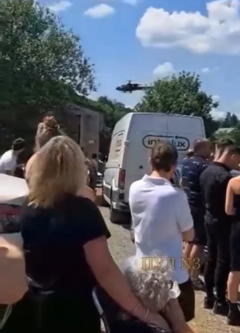 No momento do funeral, havia um grupo de pessoas vestidas de preto, incluindo amigos e familiares.  Foi nesse momento que um helicóptero aterrissou abruptamente. 